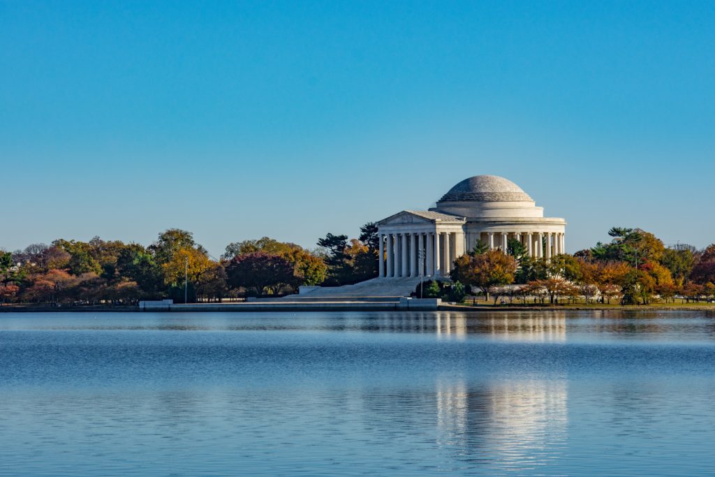 Thomas Jefferson Memorial surrounded by the lake and trees under the sunlight in Washington DC
